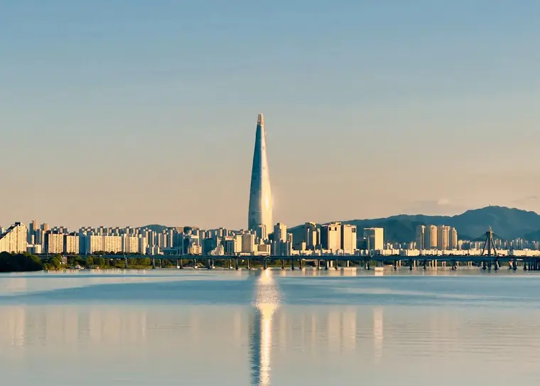The Han river at golden hour, Lotte World Tower reflected in still water